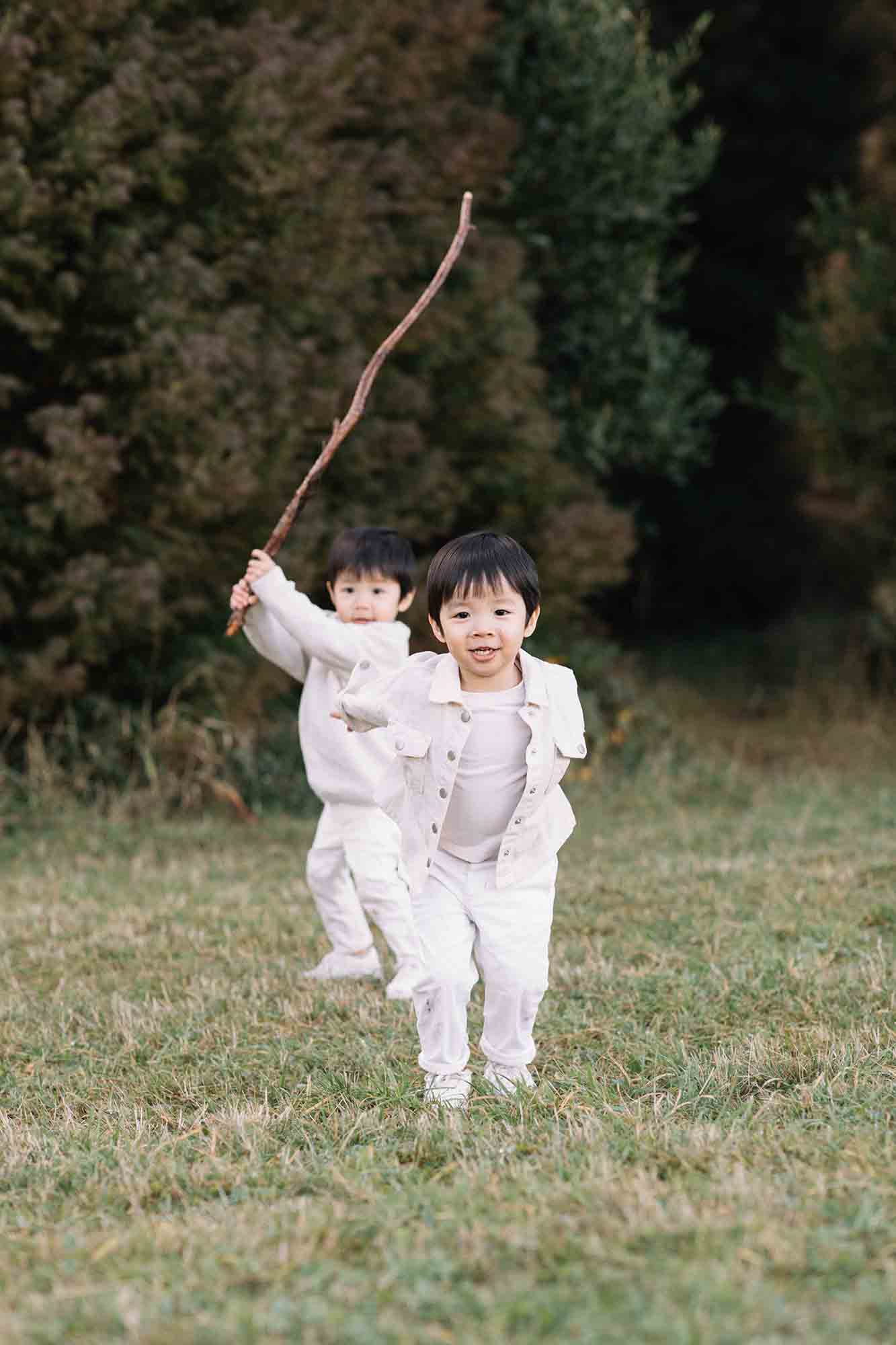 twin boys with sticks